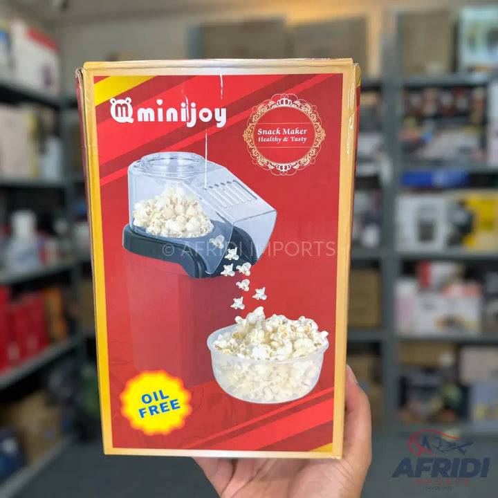 A red and yellow box for a Minijoy popcorn maker that makes oil-free snacks.