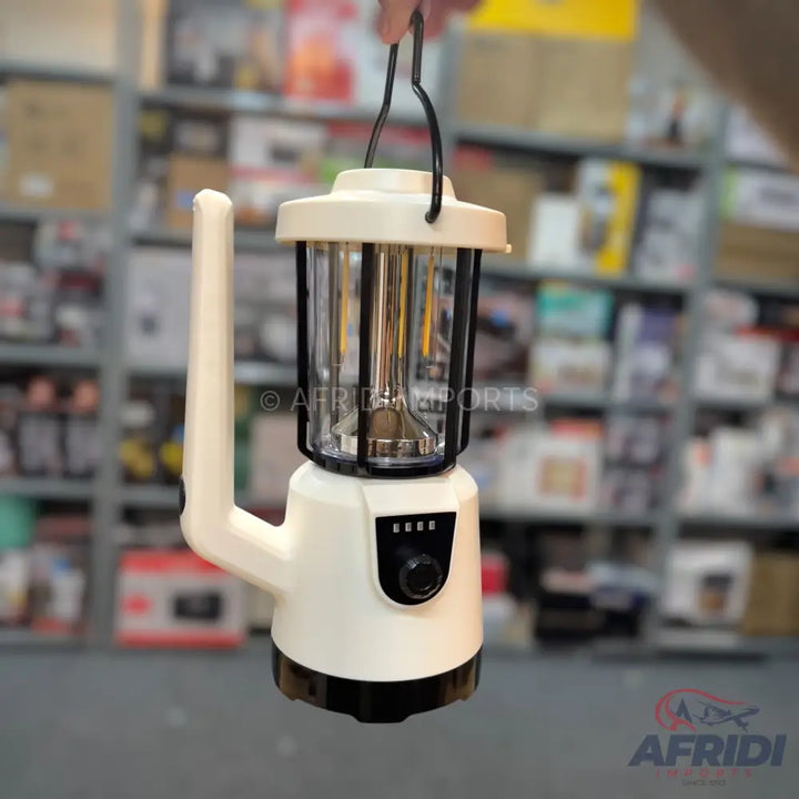 White and black portable camping lantern with an adjustable handle and a power indicator.