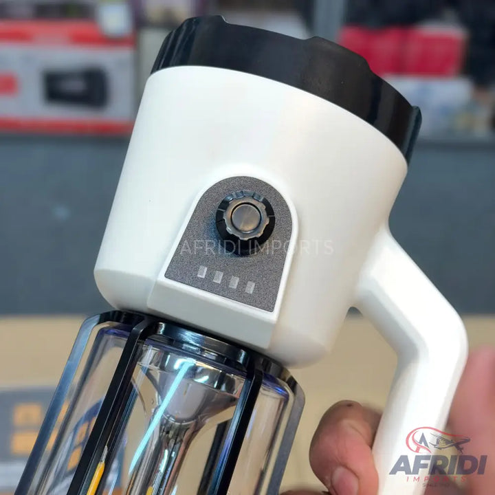 A white portable lantern with a black top, a clear base, a handle, a rotary switch, and a four-segment battery indicator.