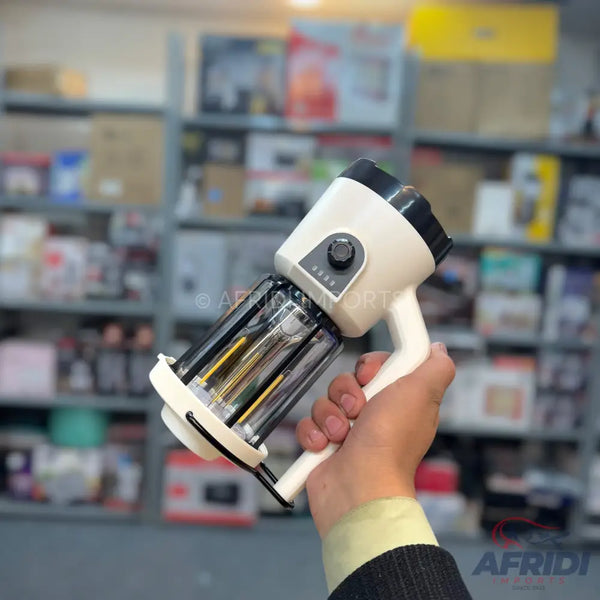 A handheld, white and black portable blender with a clear mixing chamber and a power level indicator.
