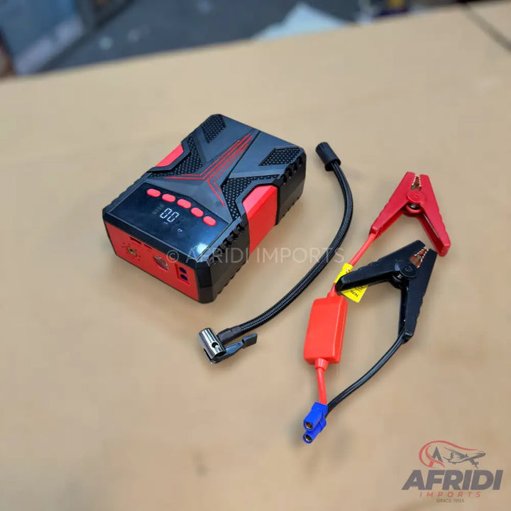 Portable car jump starter kit with battery clamps and tire inflator attachment.