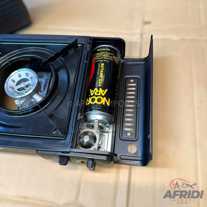 A portable gas stove with an inserted butane gas canister.