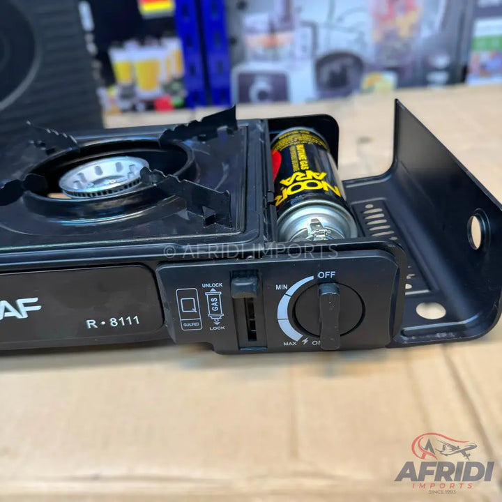 Portable black gas stove with a single burner and a fuel canister.
