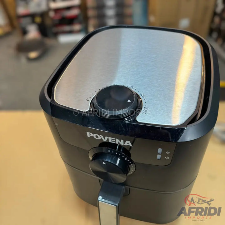 Black air fryer with a metallic top and two control knobs.