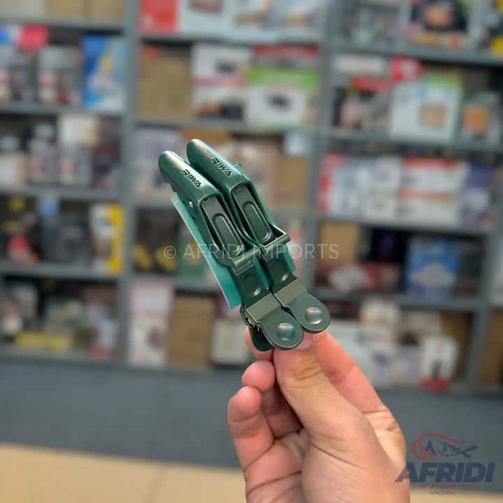 Two dark green hair styling clips held by a hand.