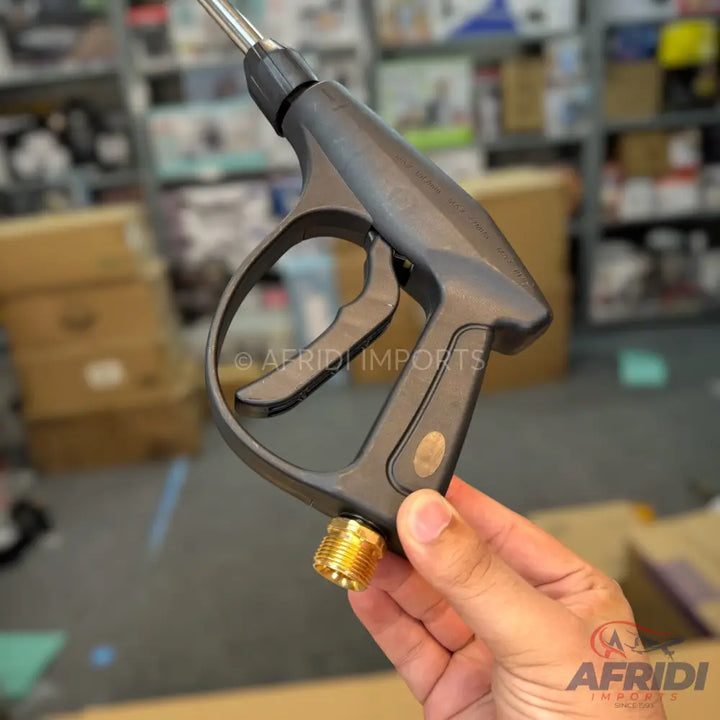 Black plastic pressure washer gun with a brass threaded fitting.