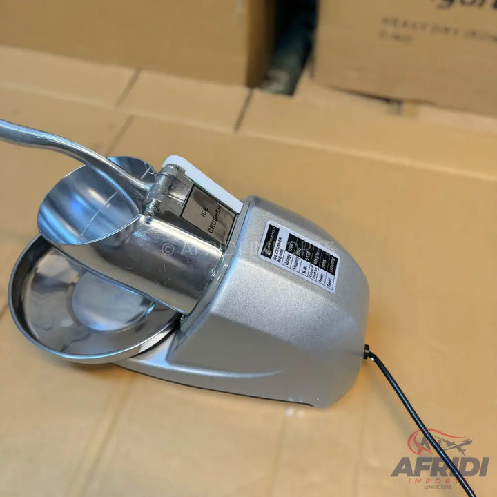 Silver electric ice shaver with a metal bowl and a spoon.
