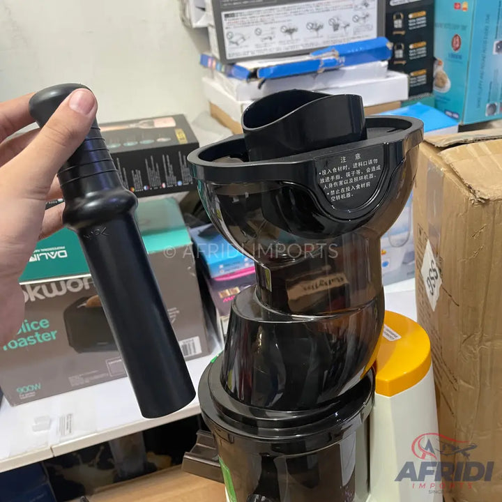 A black and white juicer with a black plunger.