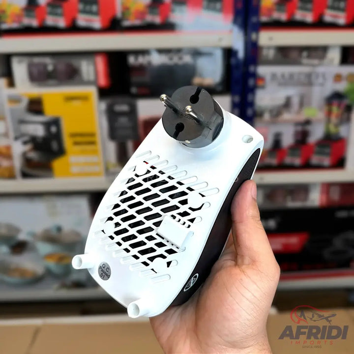 A compact, white and black portable electric heater with a three-pin plug.