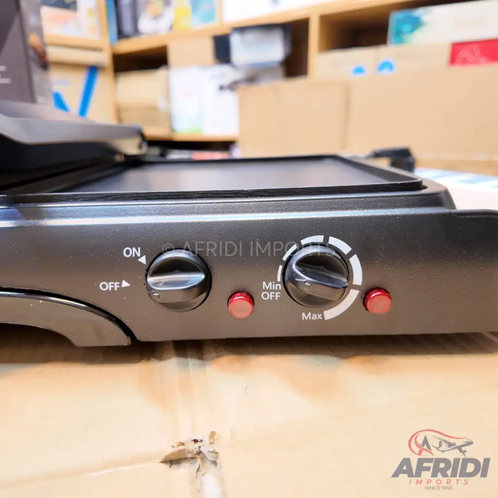 A black electric griddle or grill with two control knobs and two indicator lights.