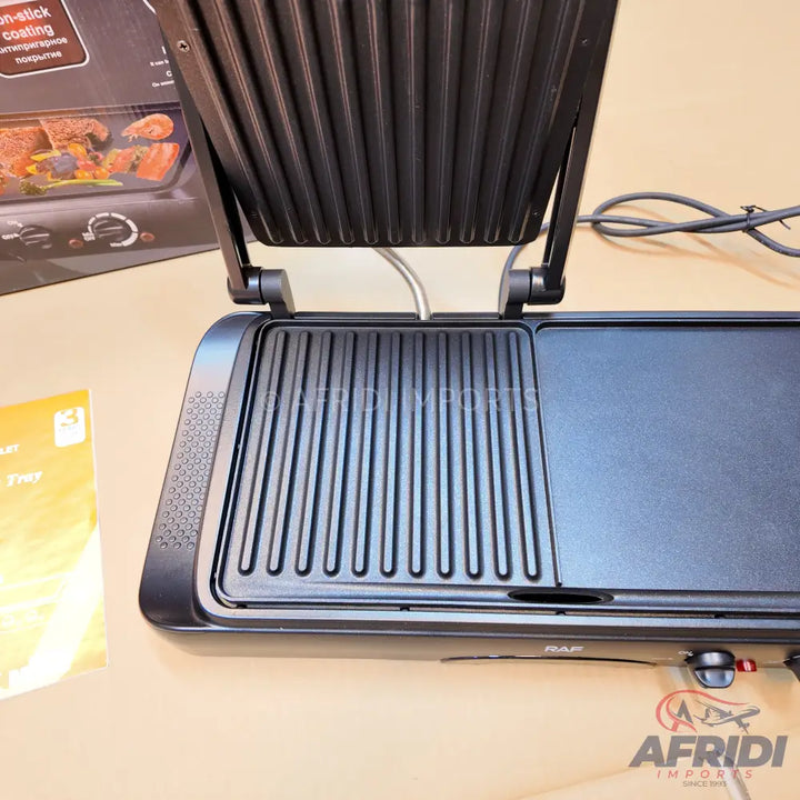 An open electric grill with both ribbed and flat cooking surfaces.