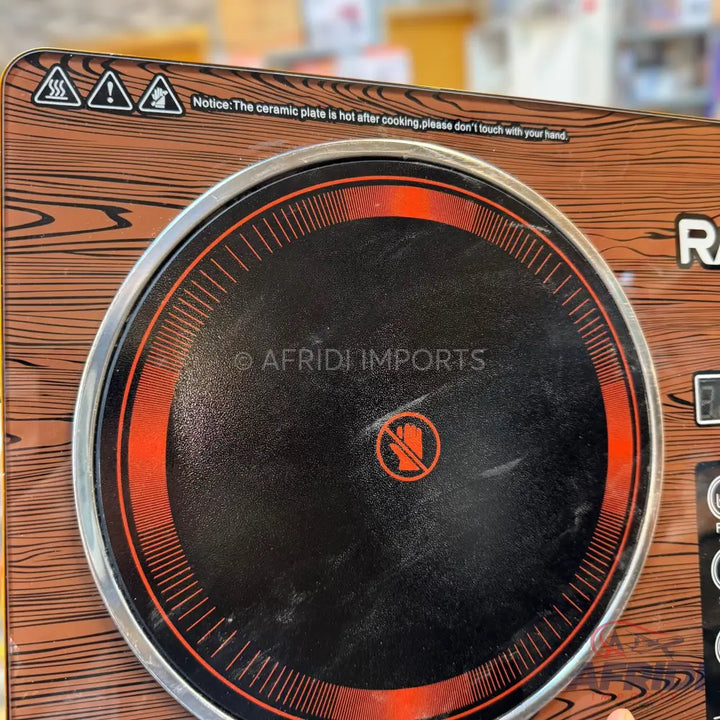 A portable electric cooktop with a single circular burner and a wood grain finish.