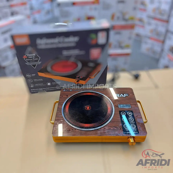 An electric infrared cooker with a faux wood grain finish and gold-colored handles.