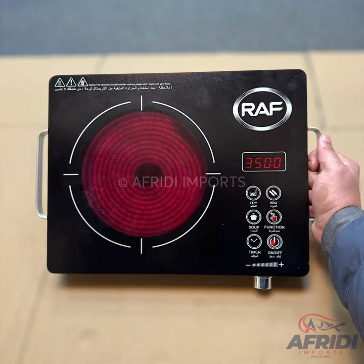 Black single-burner electric induction cooker with a red heating element and digital display.