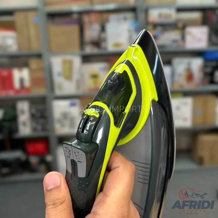 A handheld steam iron with a black and neon green design.