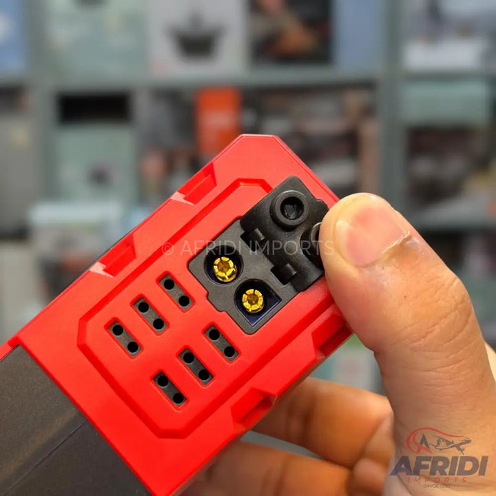 Red and black portable battery charger with multiple ports.