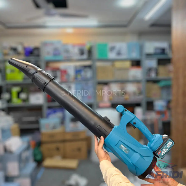 A cordless leaf blower with a black nozzle and a teal body, powered by a removable battery.
