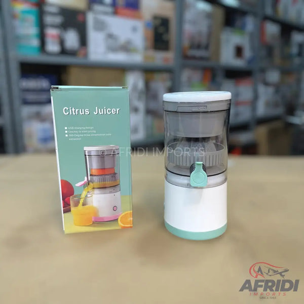 A white and mint green portable citrus juicer with a transparent top, accompanied by its packaging.