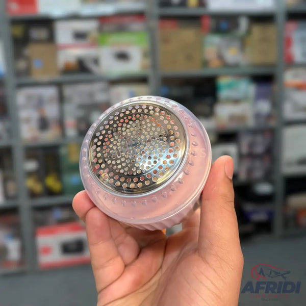 Pink and clear handheld lint remover with a metallic mesh head.