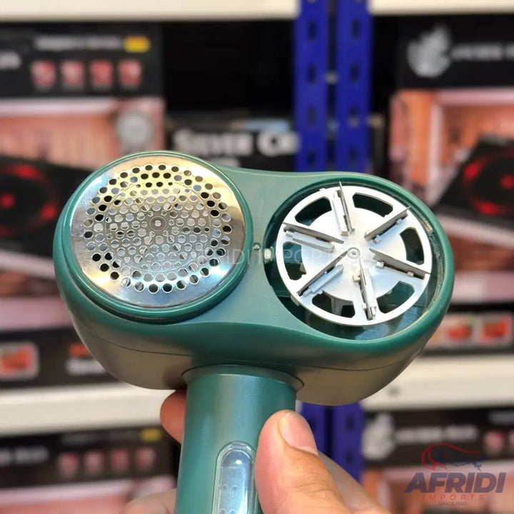 Green handheld fabric shaver with a metal mesh and an internal rotating blade.