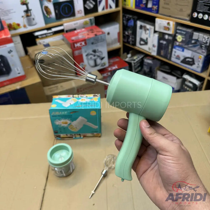 Light green handheld electric whisk with a metal whisk attachment.