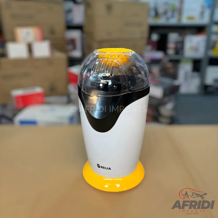 White and black popcorn maker with a clear top and yellow base.