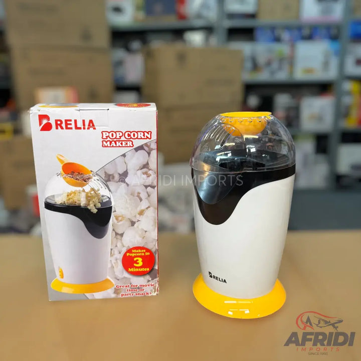 White and black electric popcorn maker with a yellow base, sold with its product box.