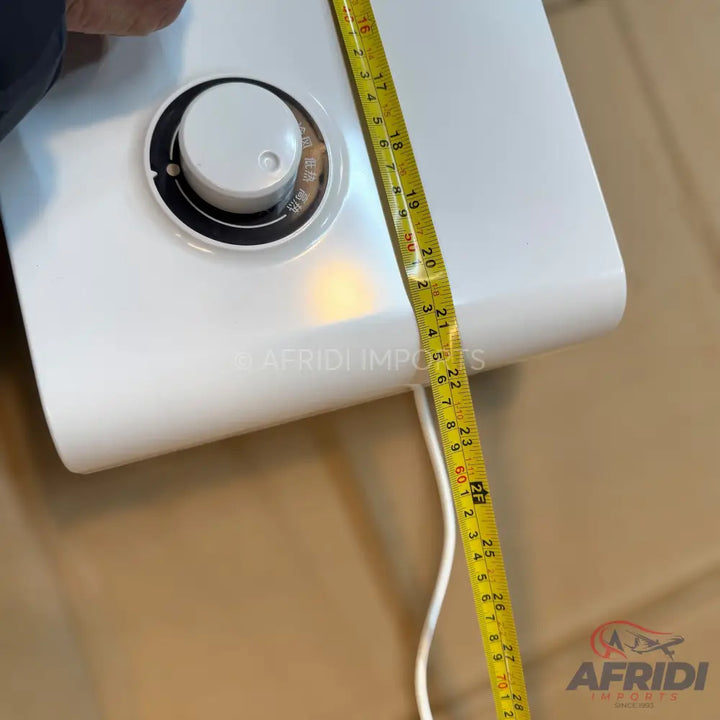 White water heater with a circular temperature control dial and a measuring tape indicating its length.