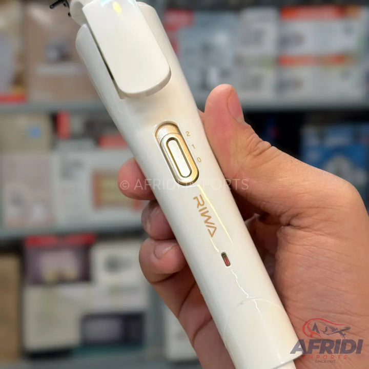 White electric hair trimmer with a gold power button.