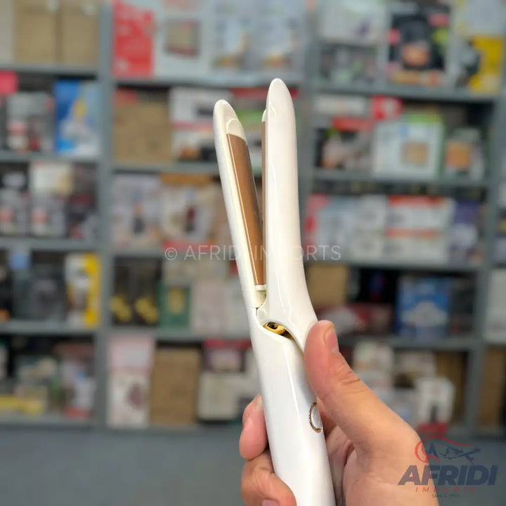 White cordless hair straightener with gold-colored heating plates.