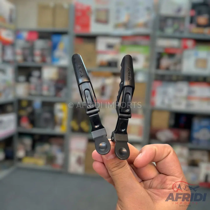 Two black plastic hair clips with metal springs and flat tips.