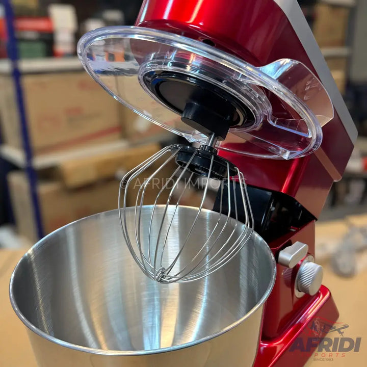 A red stand mixer with a stainless steel mixing bowl and a wire whisk attachment.