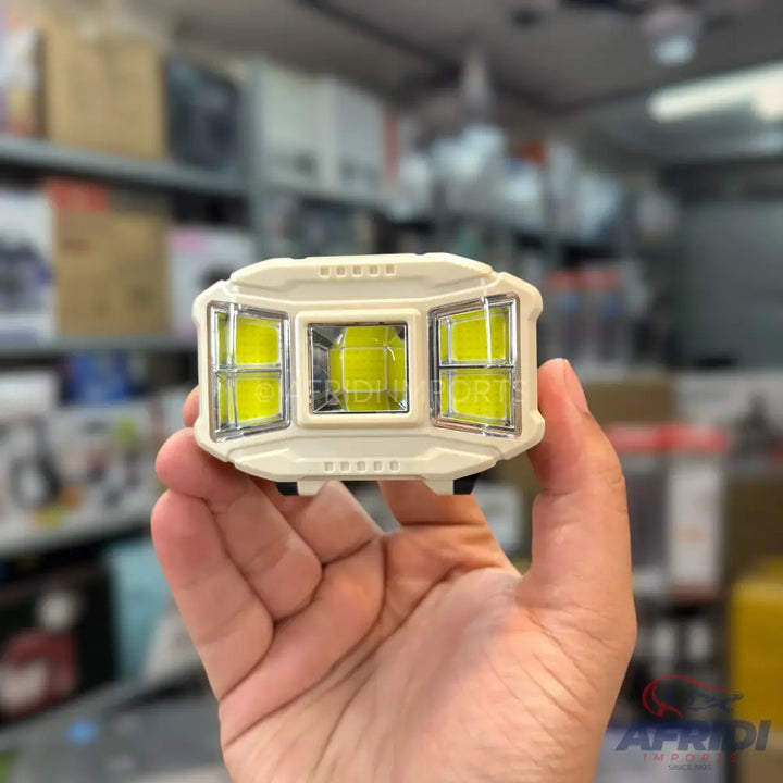A beige headlamp with three bright yellow-green LED light panels.