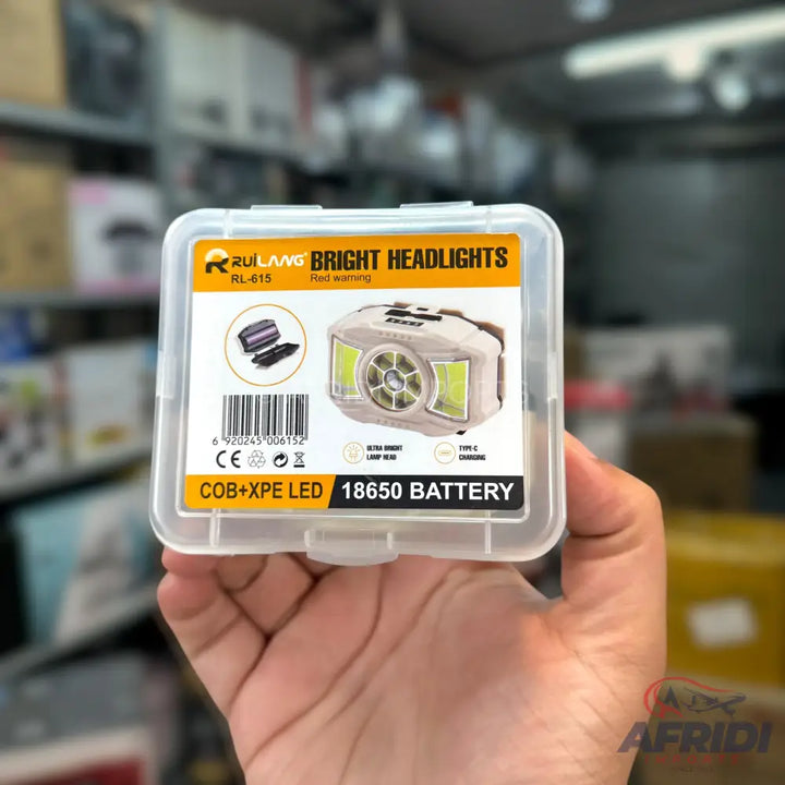 A white headlamp with multiple LED lights and a rechargeable 18650 battery, packaged in a clear plastic case.