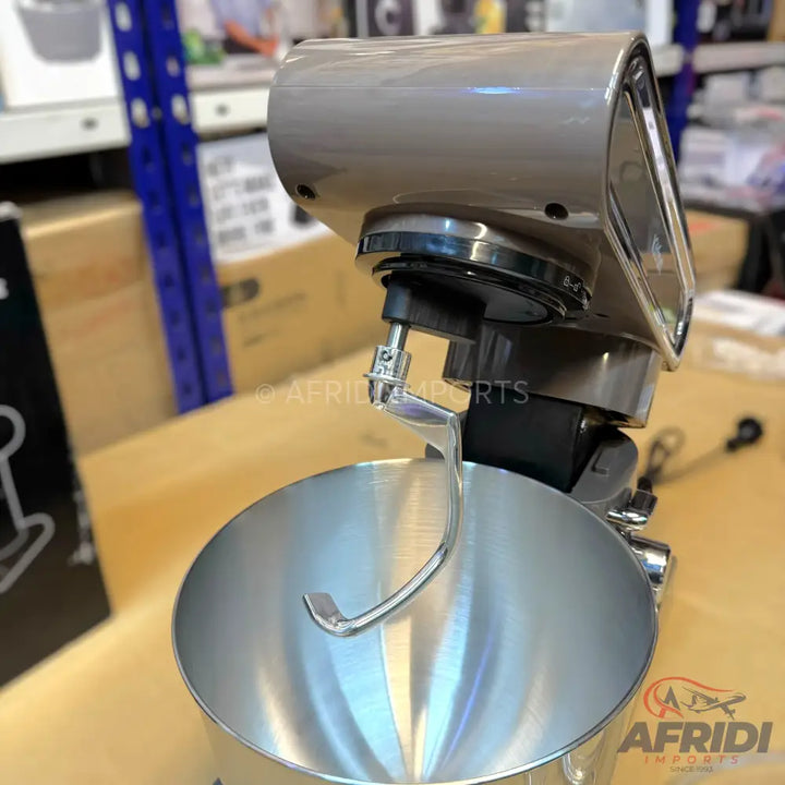 A sleek, metallic grey stand mixer with a stainless steel bowl and a dough hook attachment.