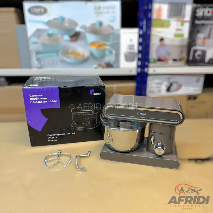 A dark grey stand mixer with a stainless steel bowl and two attachments.