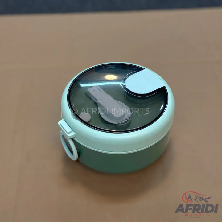 Two-tiered round lunchbox with a transparent lid, a built-in spoon, and a carrying handle.