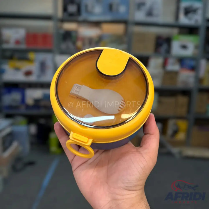 Yellow round lunchbox with a clear lid and an included spork.