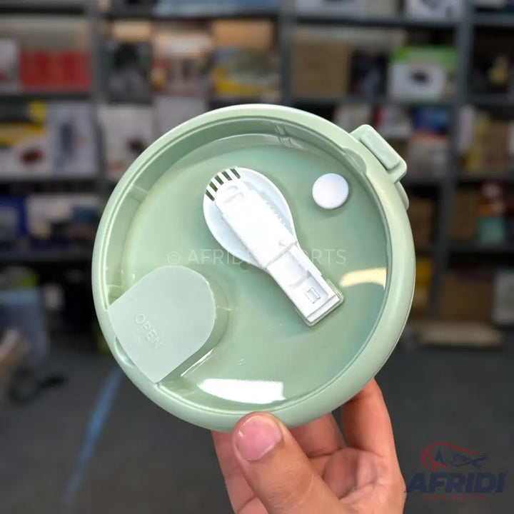 Light green round meal container with an integrated spork and a small white cap.