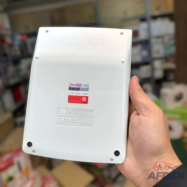 White calculator held in a hand.