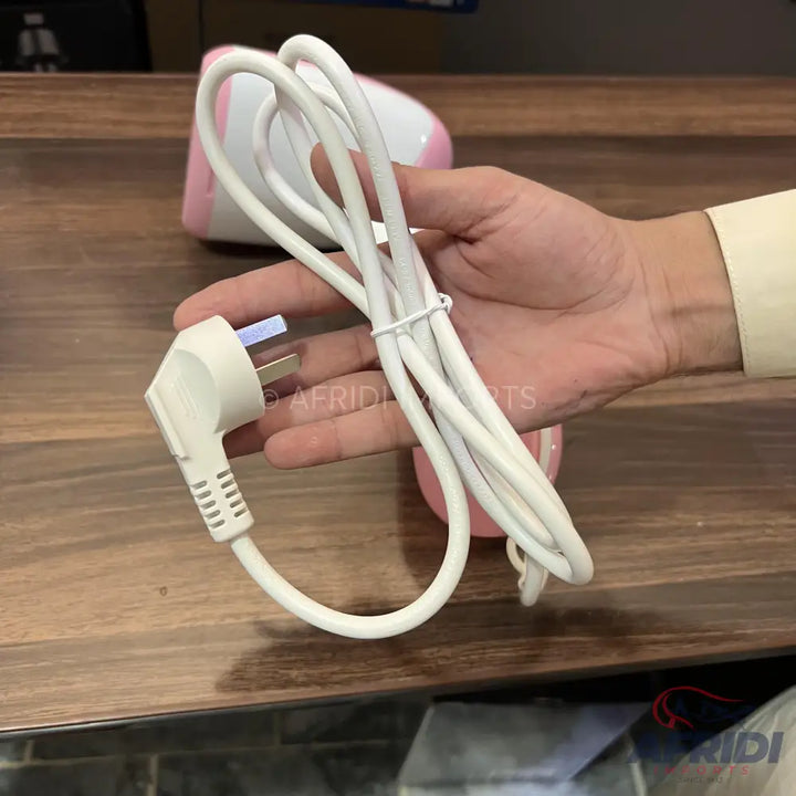 A white power cord with a three-prong plug, coiled and held in a hand.