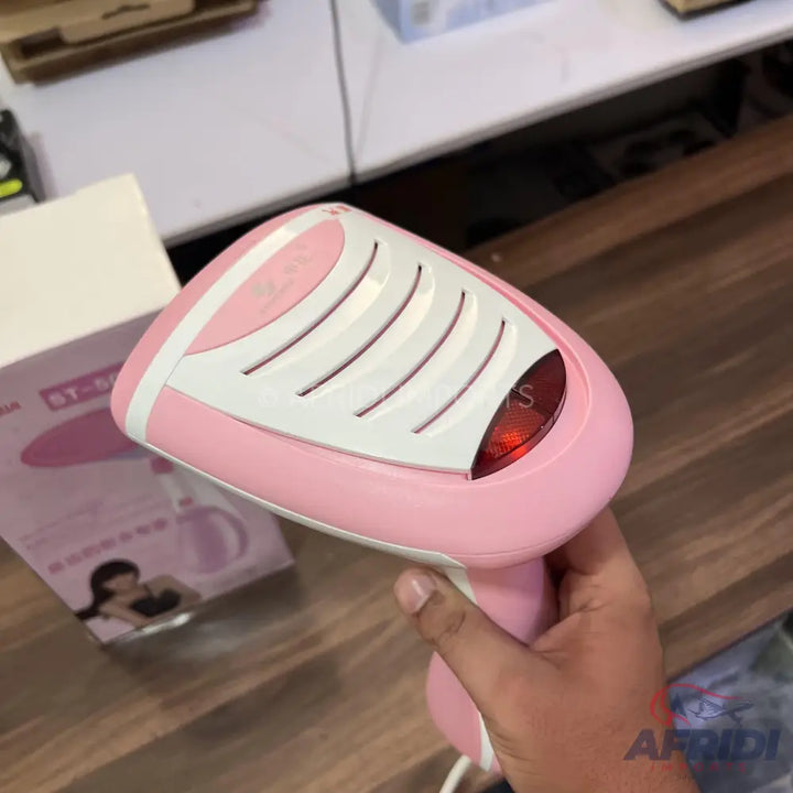 Pink and white handheld garment steamer with a red indicator light.