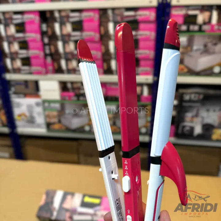 Three hair styling tools, including a crimper, a straightener, and a curling iron, in white and pink.