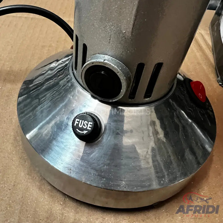 A metal base of a kitchen appliance with a fuse cap and a red power switch.