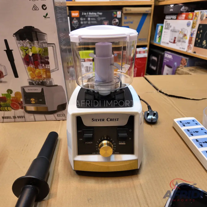 A white and gold food processor with a clear bowl and a black power cord.
