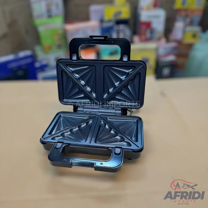 Open black electric sandwich maker with triangular plates.