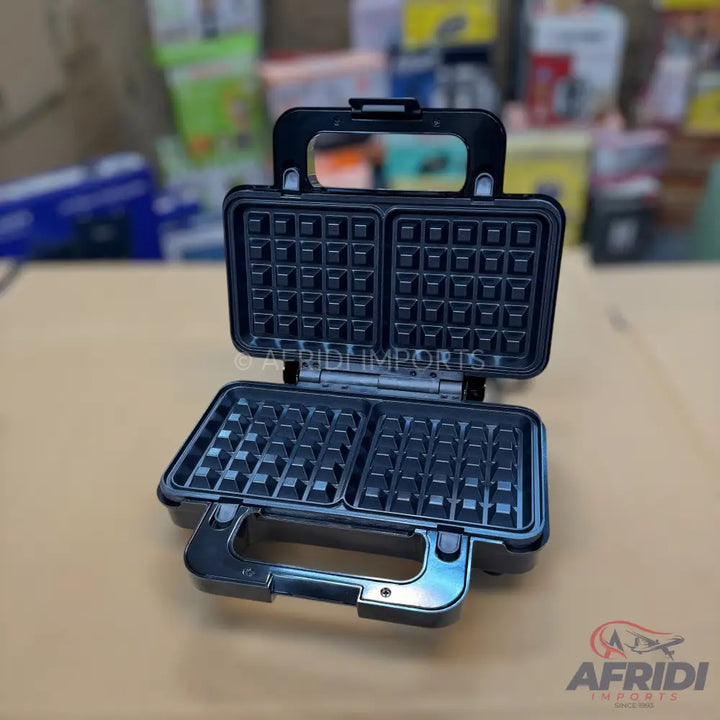 Open black electric waffle maker with two square cooking plates.