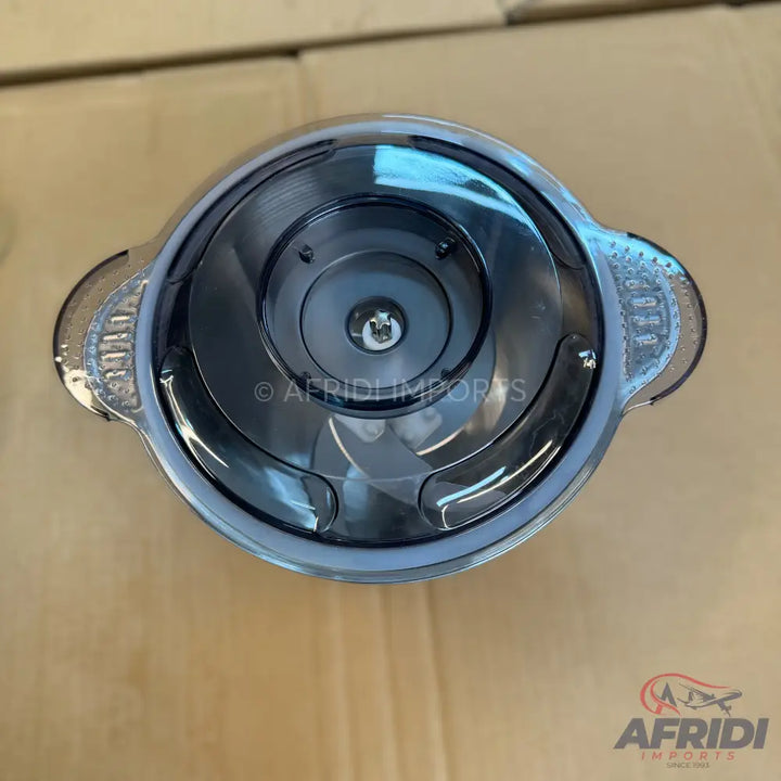 A top-down view of a food chopper with a transparent lid and stainless steel blades.