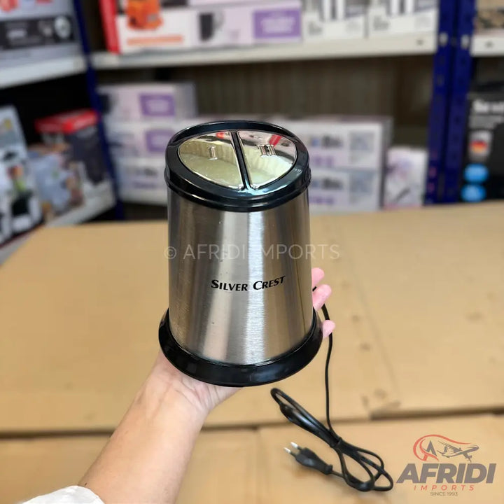 Silver Crest electric coffee grinder with a stainless steel body and two transparent top compartments.