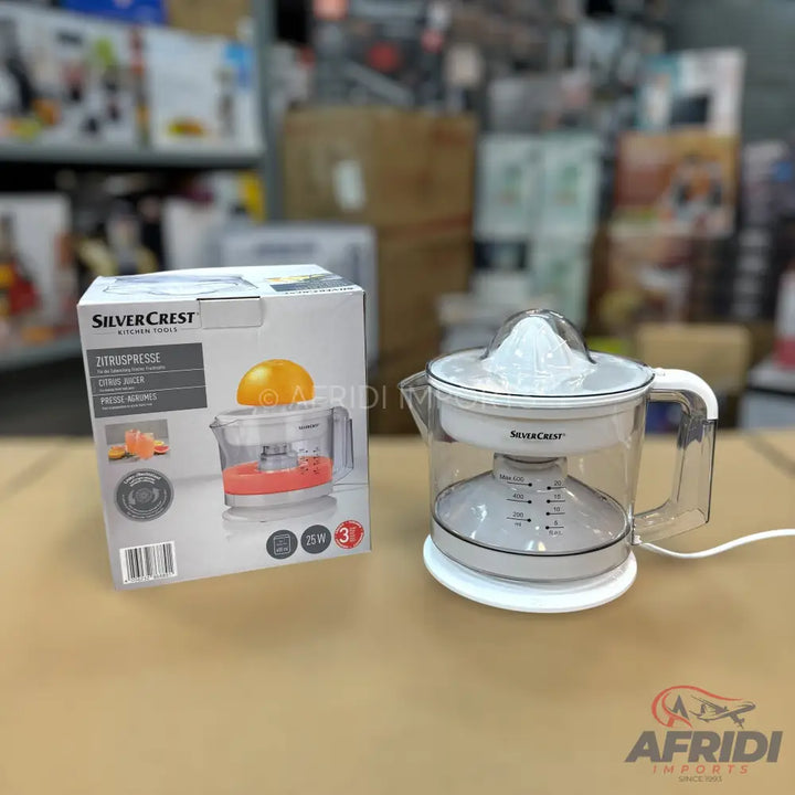 A SilverCrest electric citrus juicer with a clear pitcher and a white lid, accompanied by its original packaging.